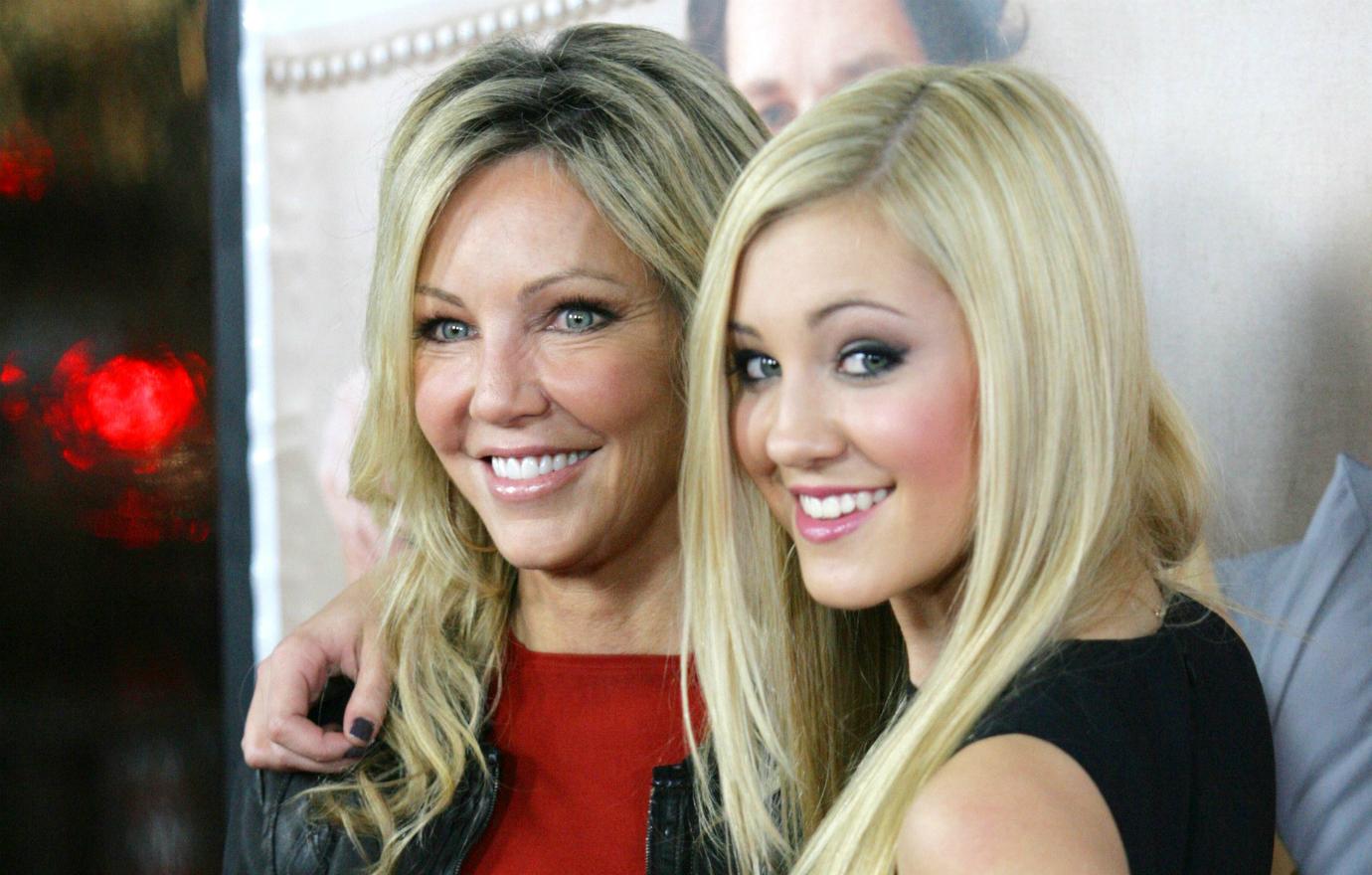 Heather Locklear, in a red top, poses with daughter Ava who wears a black dress.