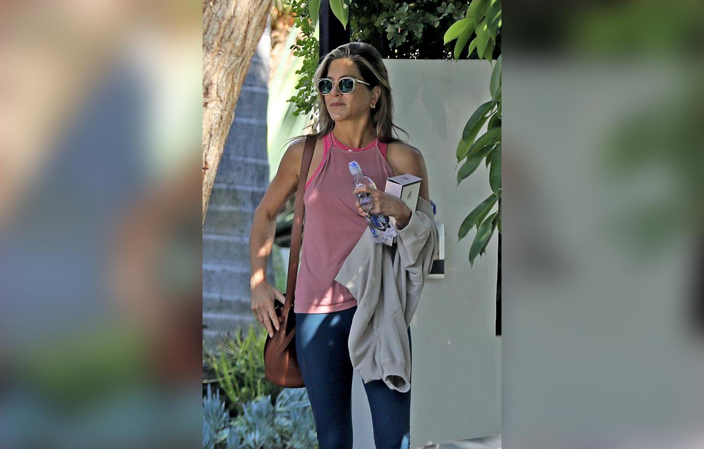 Jennifer Aniston Wearing Sunglasses Pink Tank Top and Navy Leggings Flaunts Body