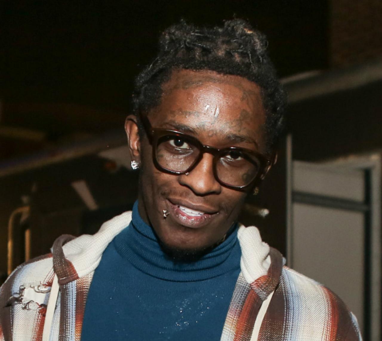 Young Thug smiles for a picture.