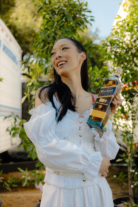 rina sawayama celebrates an epic performance backstage at risings head in the clouds festival la with a custom bottle of johnnie walker blue label