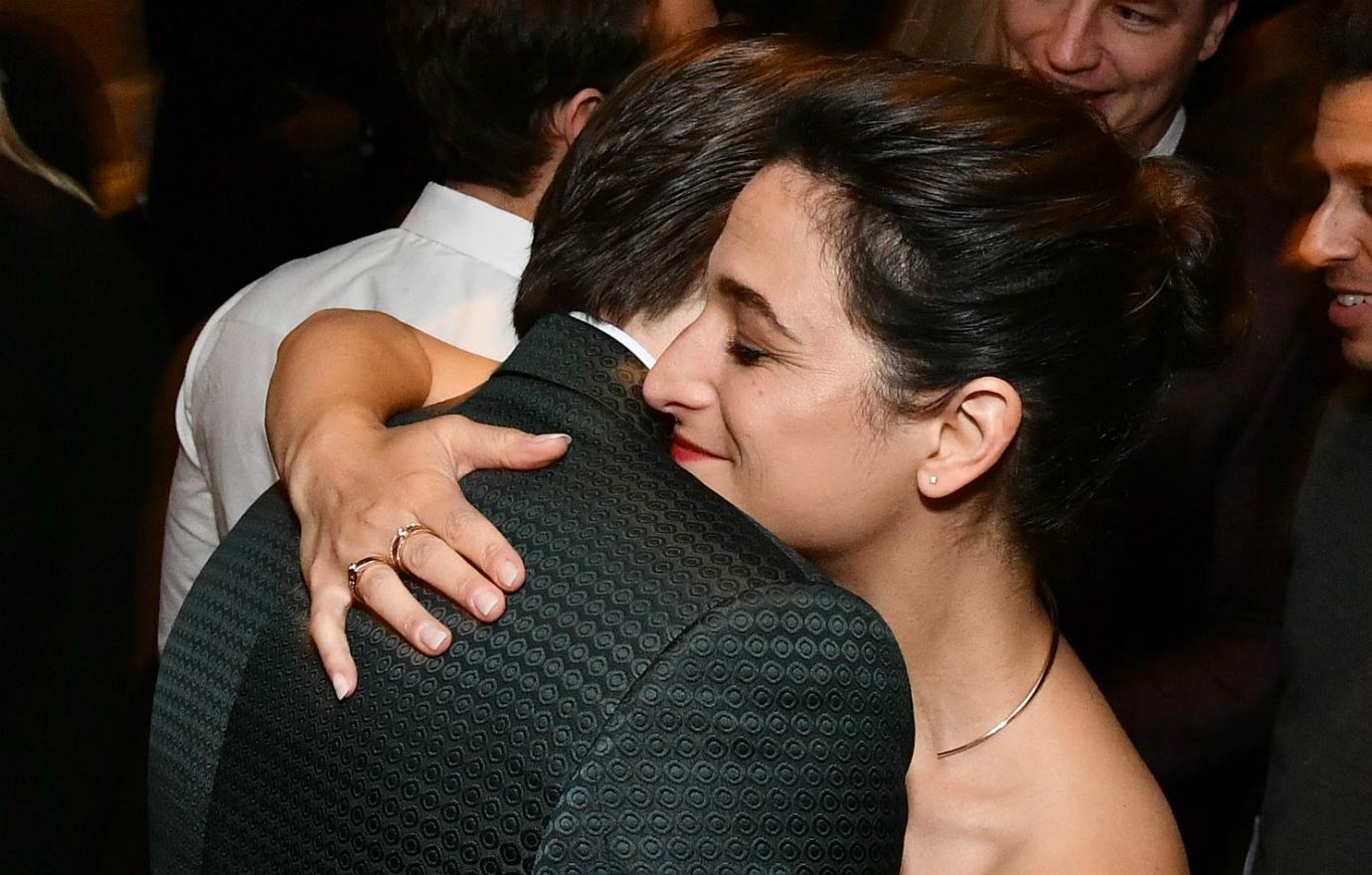 Jenny Slate, in a shoulder-exposing and sleeveless gown, gave Chris Evans, in a suit, a hug.