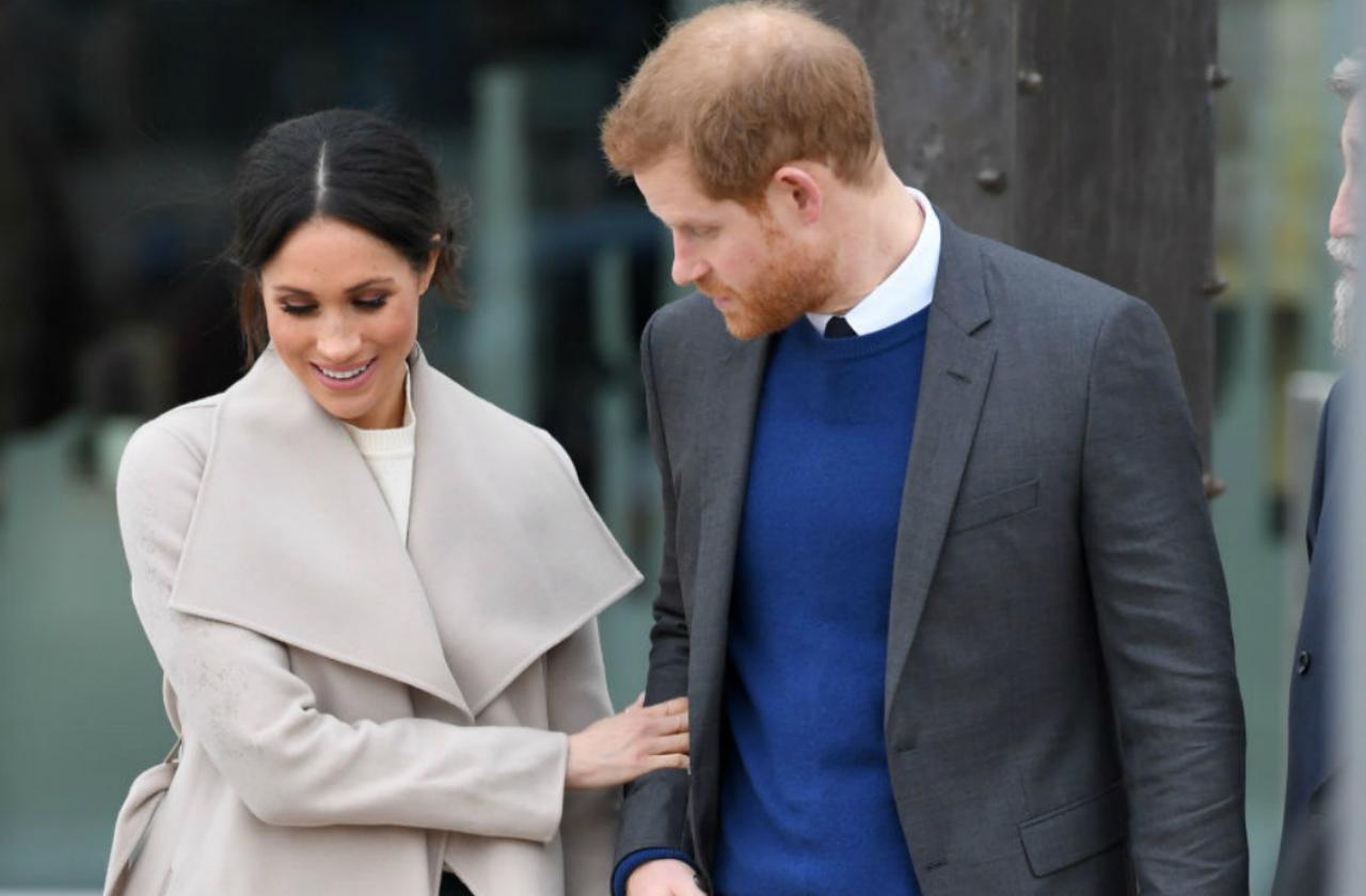 prince harry and meghan markle smiling and walking together