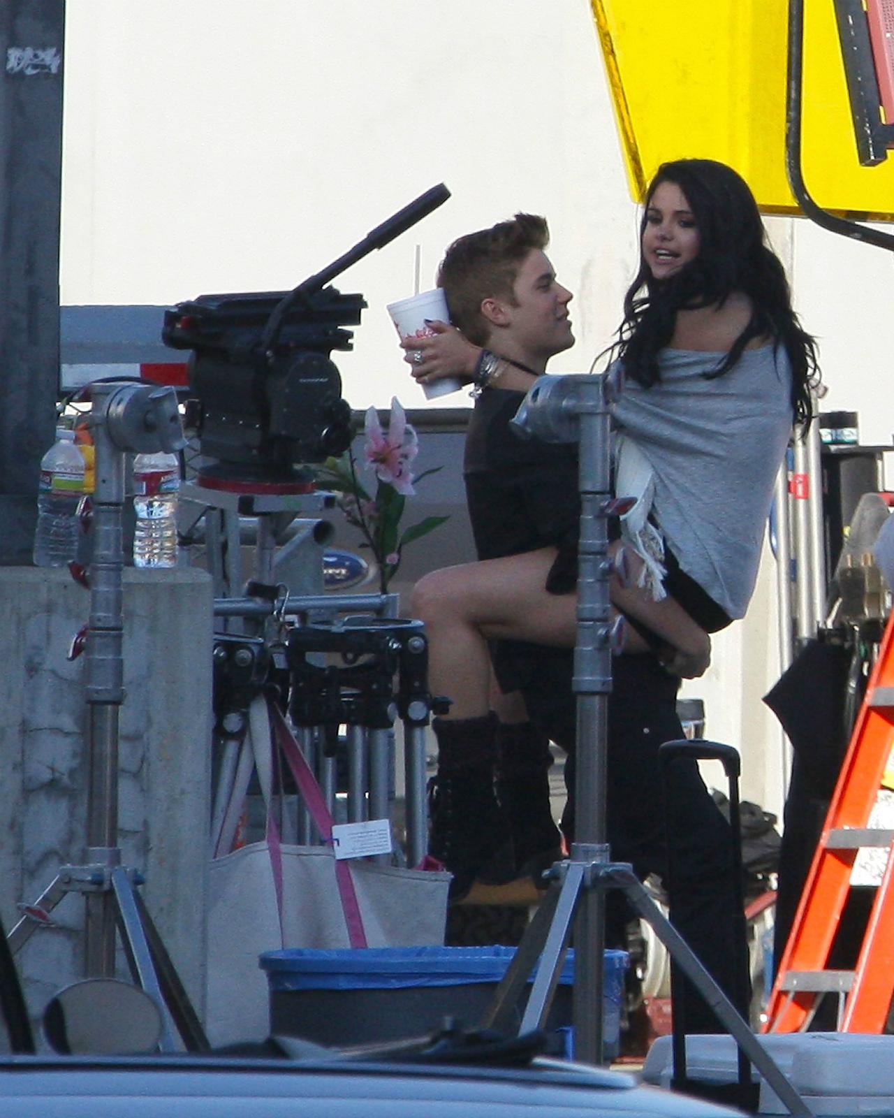 Selena Gomez wears an oversized gray sweatshirt and Justin Bieber is dressed all in black in this photo from 2012 where she visited him on set.