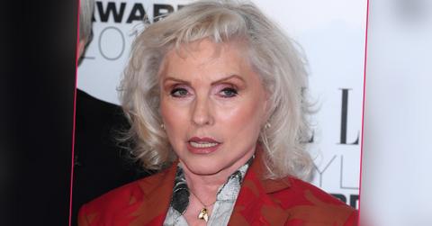 Debbie Harry wearing a red jacket and t shirt with a pattern.