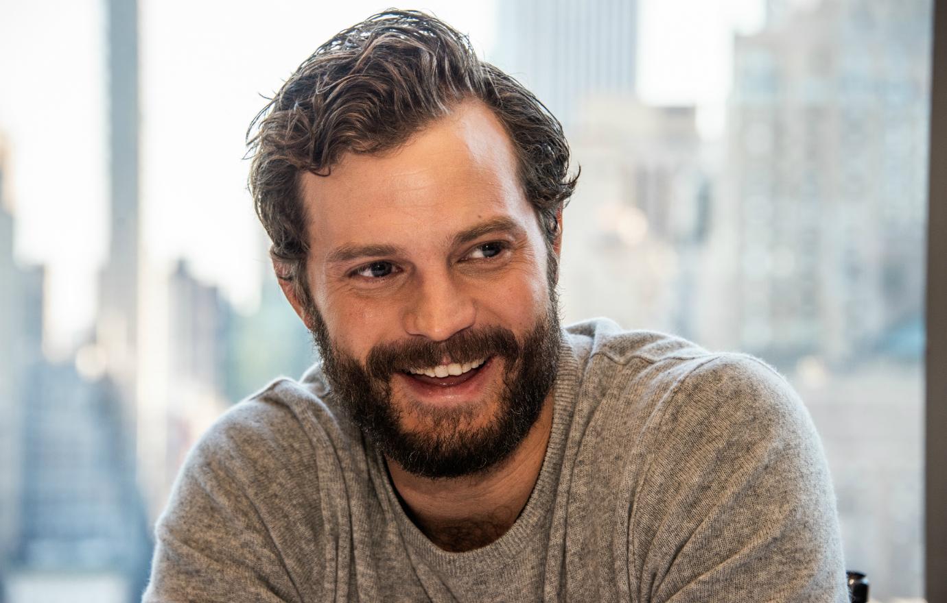 Jamie Dornan was all smiles at a press conference in casual grey sweater, a long way from Fifty Shades full frontal nudity..