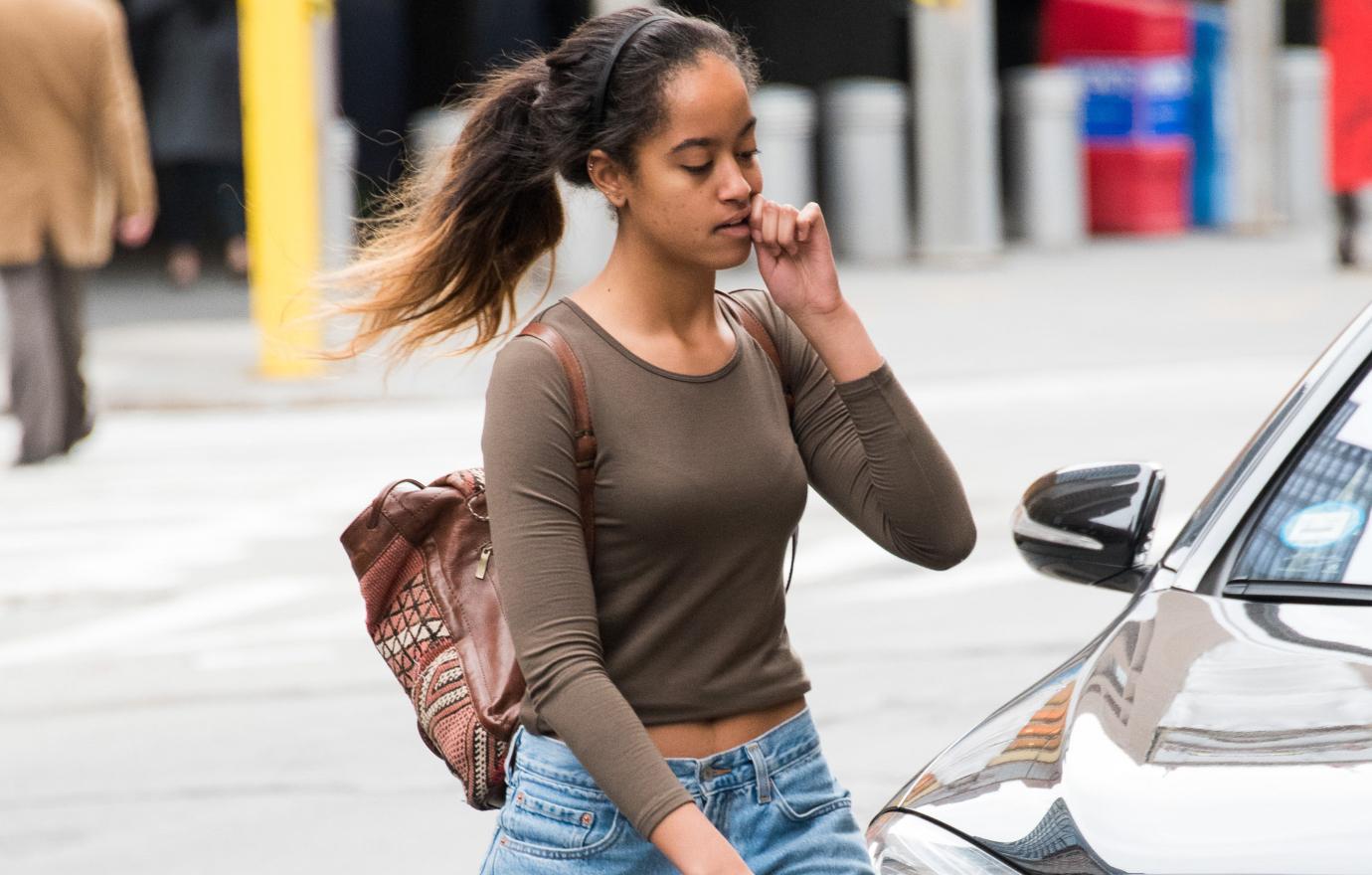 Malia walks to work in NY wearing a green shirt and blue jeans