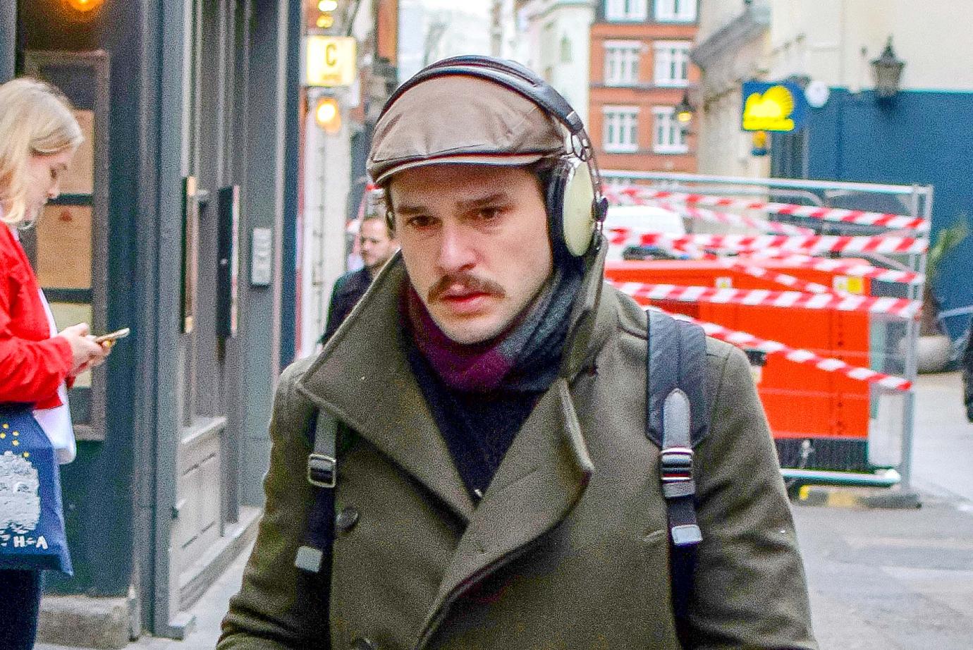 Kit Harington walks with headphones in 2019