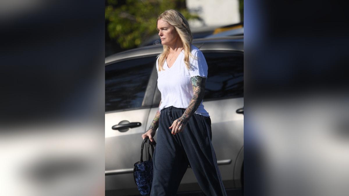 Eleniak kept her look very casual in a white T-shirt and loose navy sweatpants with slip-on shoes.