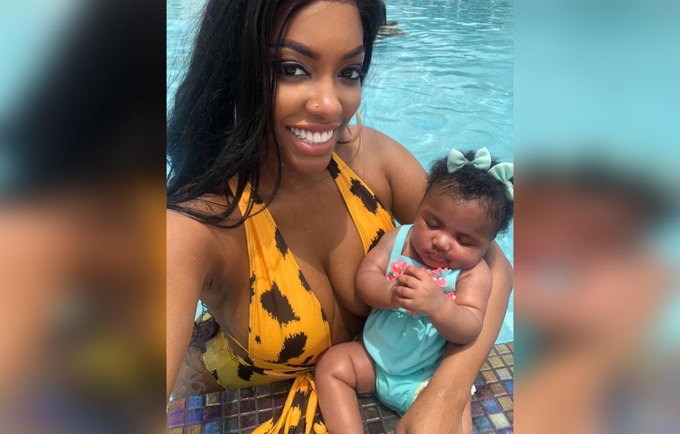 Porsha Williams In Yellow Print Swimsuit Takes a Selfie Inside Pool Smiling Holding Baby Pilar