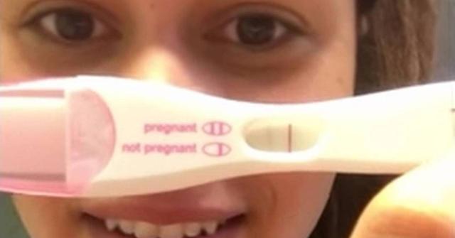 woman holding pregnancy test