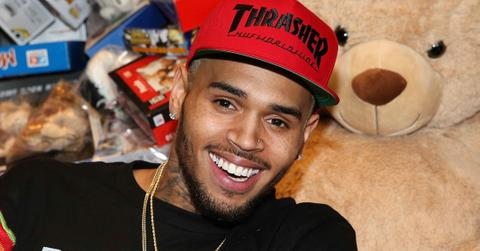Chris Brown wears a black shirt with a red cap that says THRASHER on it.