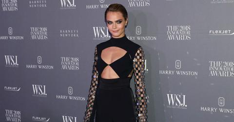 Cara Delevingne wears a black cleavage and stomach baring top and black pants, with her hair slicked back and a smoky eye makeup at the 2018 WSJ Magazine Innovator Awards.