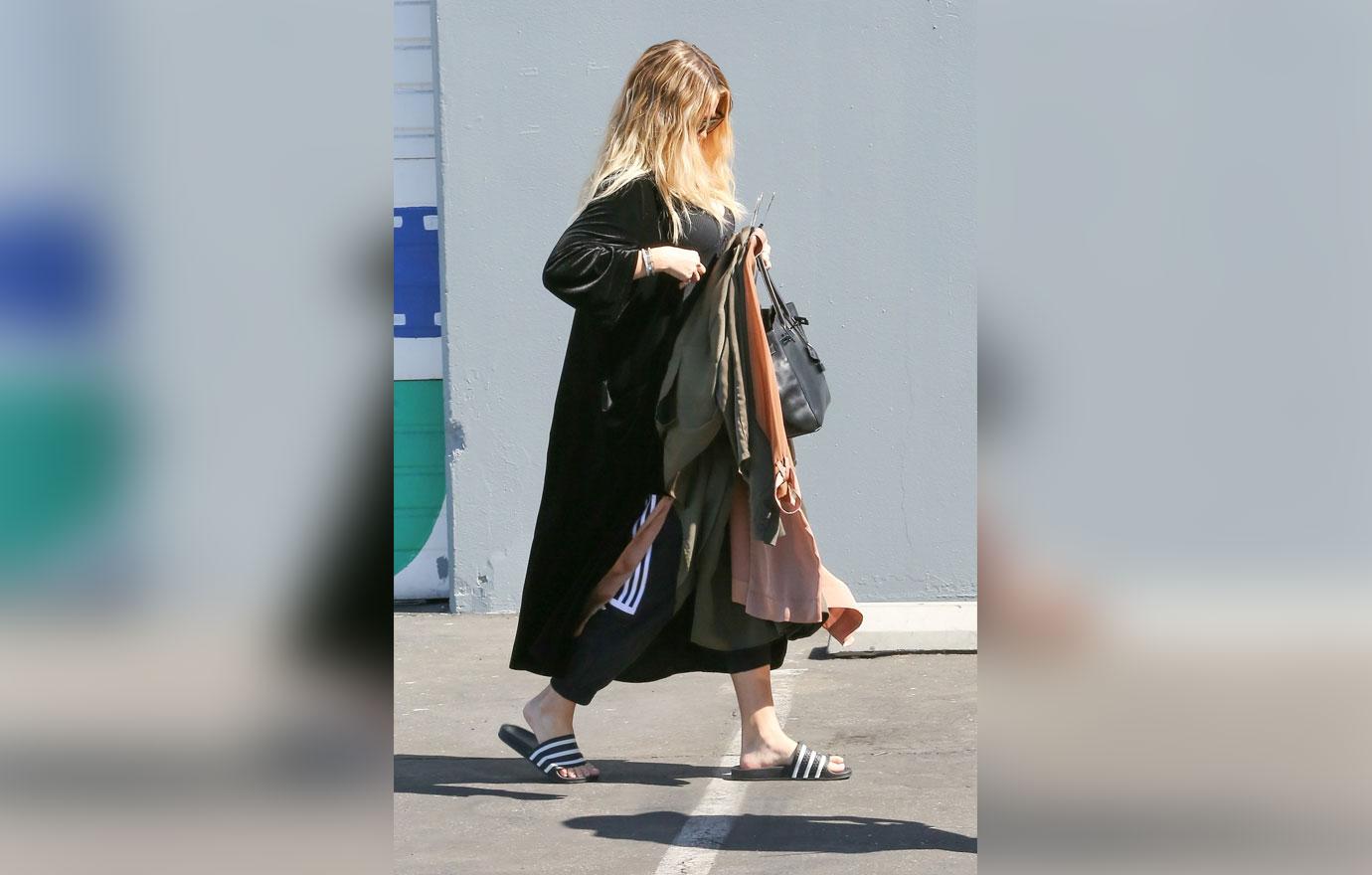 Khloe Kardashian covers baby bump