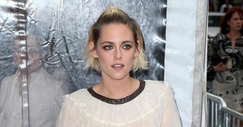 Kristen Stewart wears a flowing black dress, short hair half pulled back.