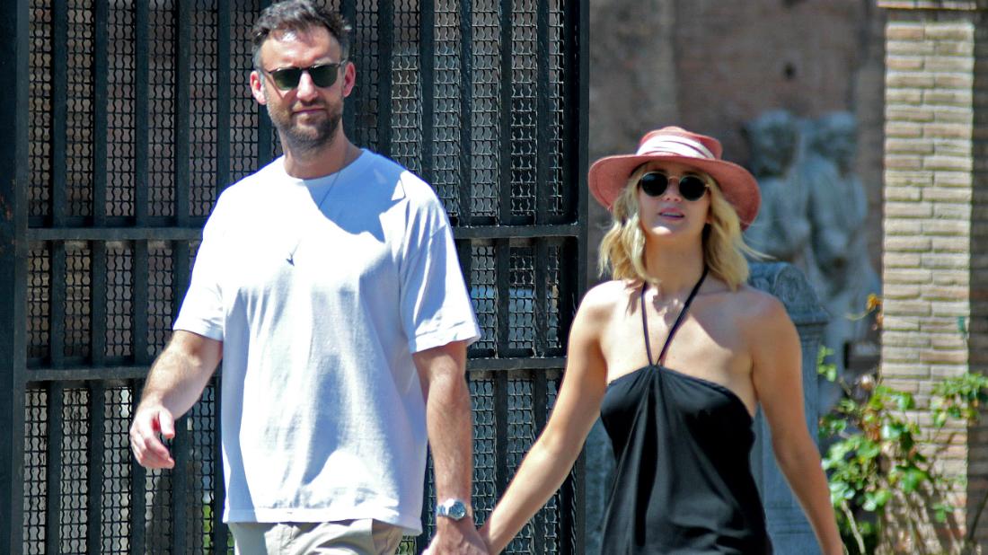 Jennifer Lawrence wore a black sundress and sun hat walking in Rome with her fiancé, Cooke Maroney, who was dressed in a T-shirt and casual slacks.