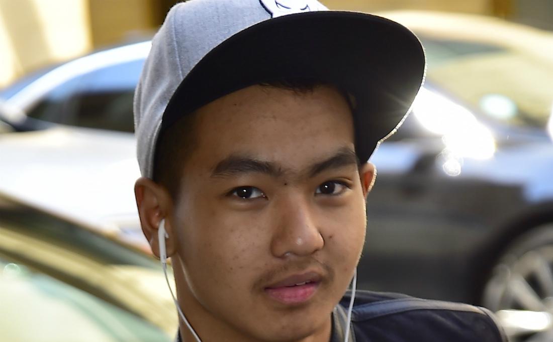 Headshot of Maddox Jolie Pitt. He’s got earbuds in and is wearing a light cap, black jacket and t-shirt.