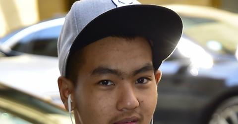 Headshot of Maddox Jolie Pitt. He’s got earbuds in and is wearing a light cap, black jacket and t-shirt.