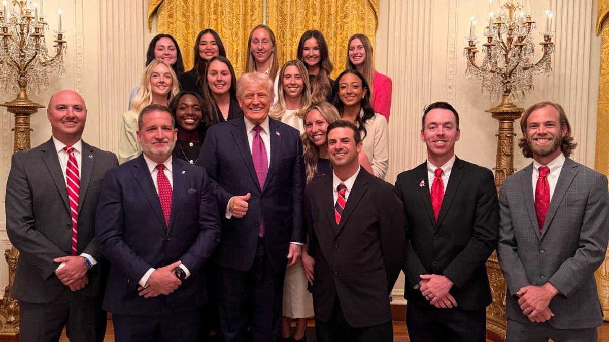 Trump stood beside male athletic directors and coaches in the front of the photo.