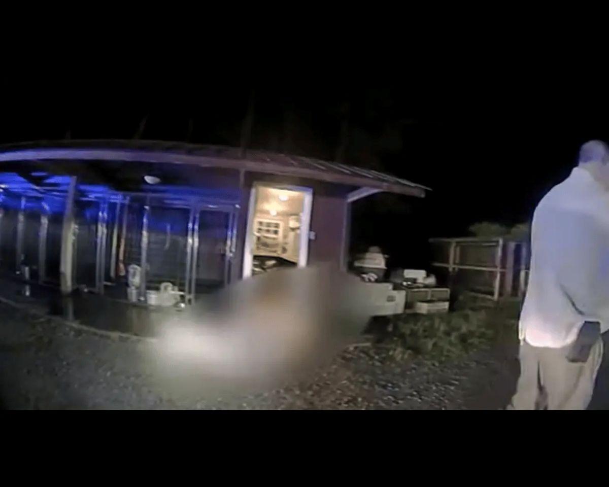 Paul Murdaugh's body is blurred and covered with a tarp outside the dog kennels.