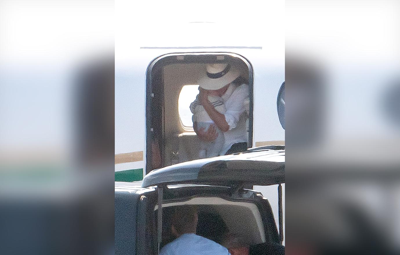 Meghan Markle cradles baby son Archie in both arms as she leaves the luxury private jet