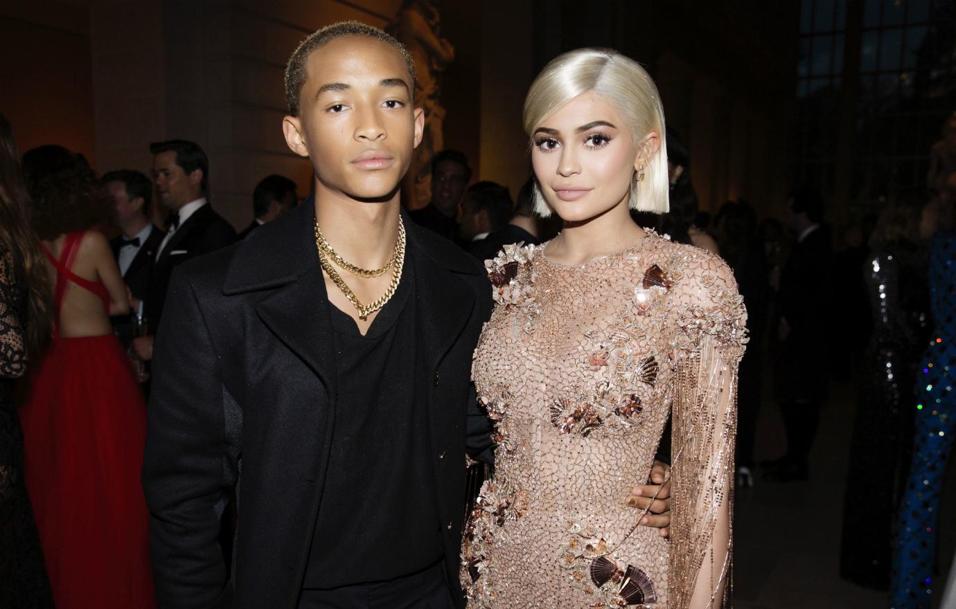 Jaden Smith, in all-black, stands next to Kylie Jenner who wears a bejeweled peach dress on the red carpet.