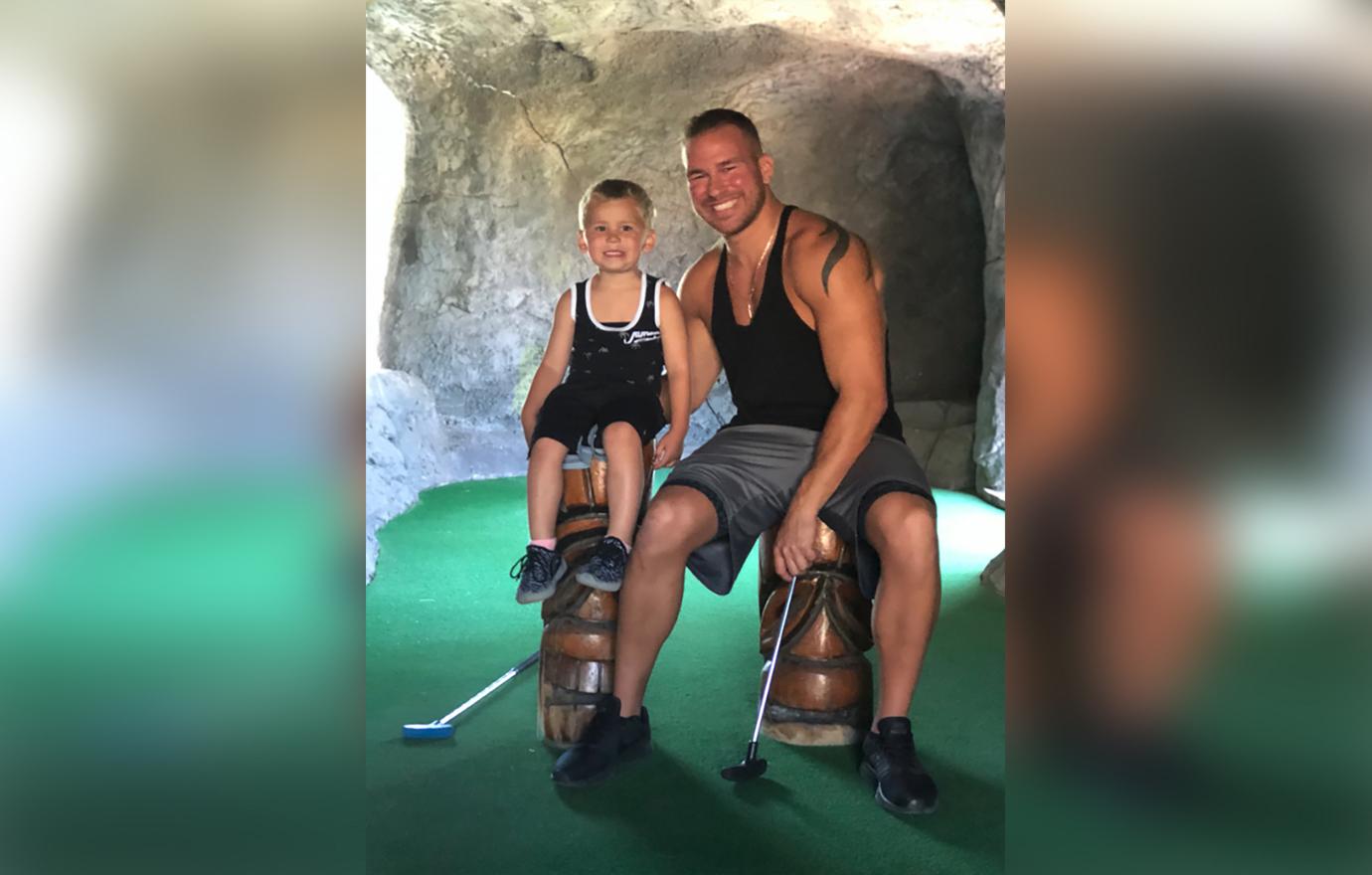 Nathan Griffith Sitting Smiling With Son Kaiser at Mini Golf