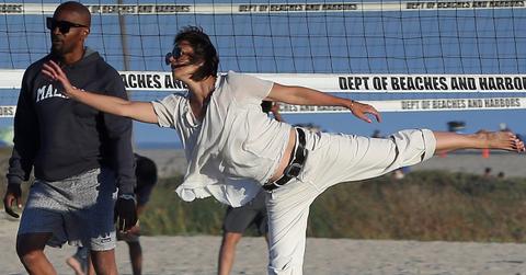 couple on beach doing yoga