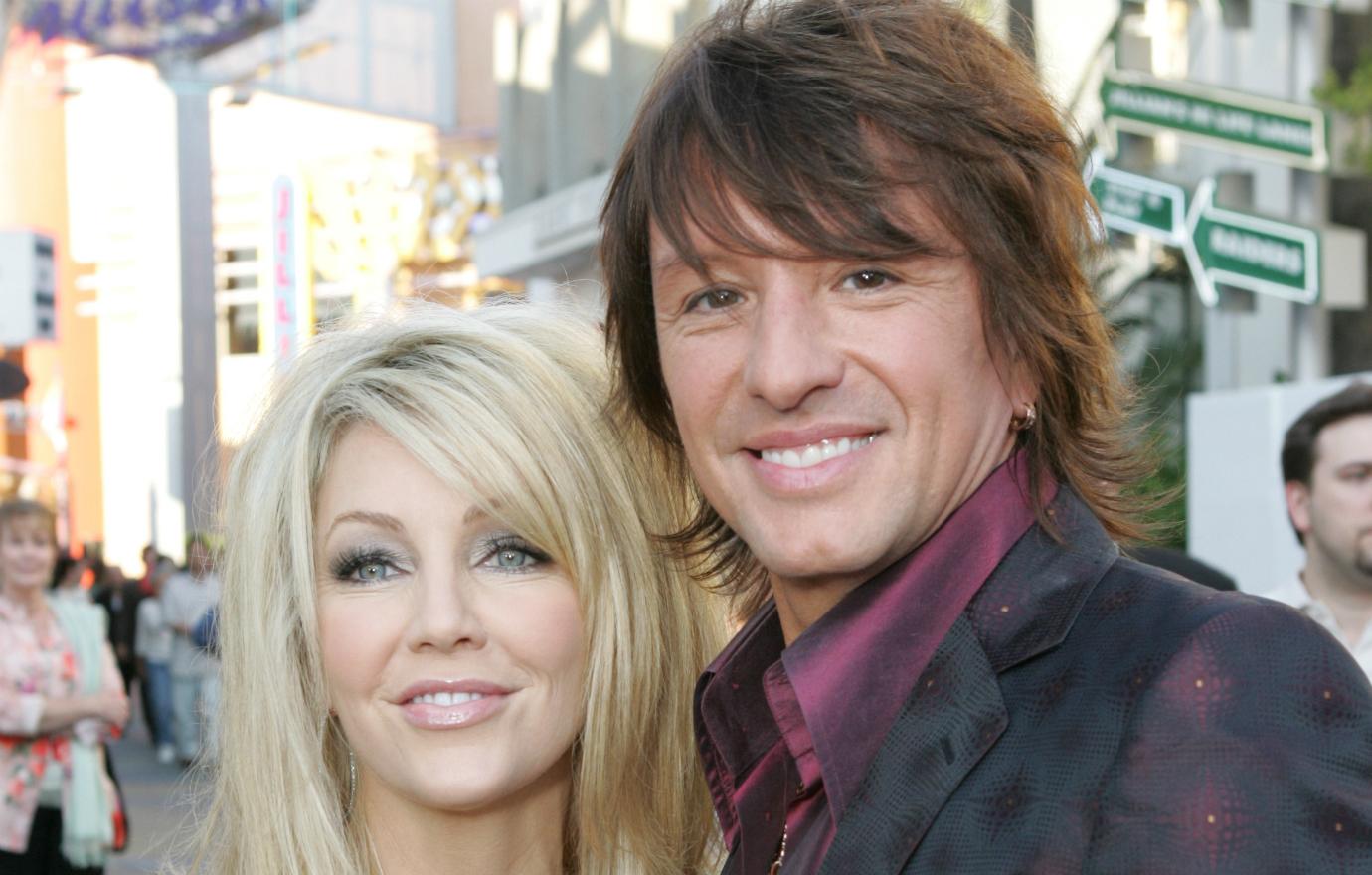 Heather Locklear stands by Richie Sambora on a red carpet.