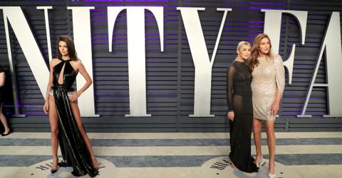 Sophia Hutchins, in a sheer black dress, stands with Caitlyn Jenner who wears a sparkly white dress.