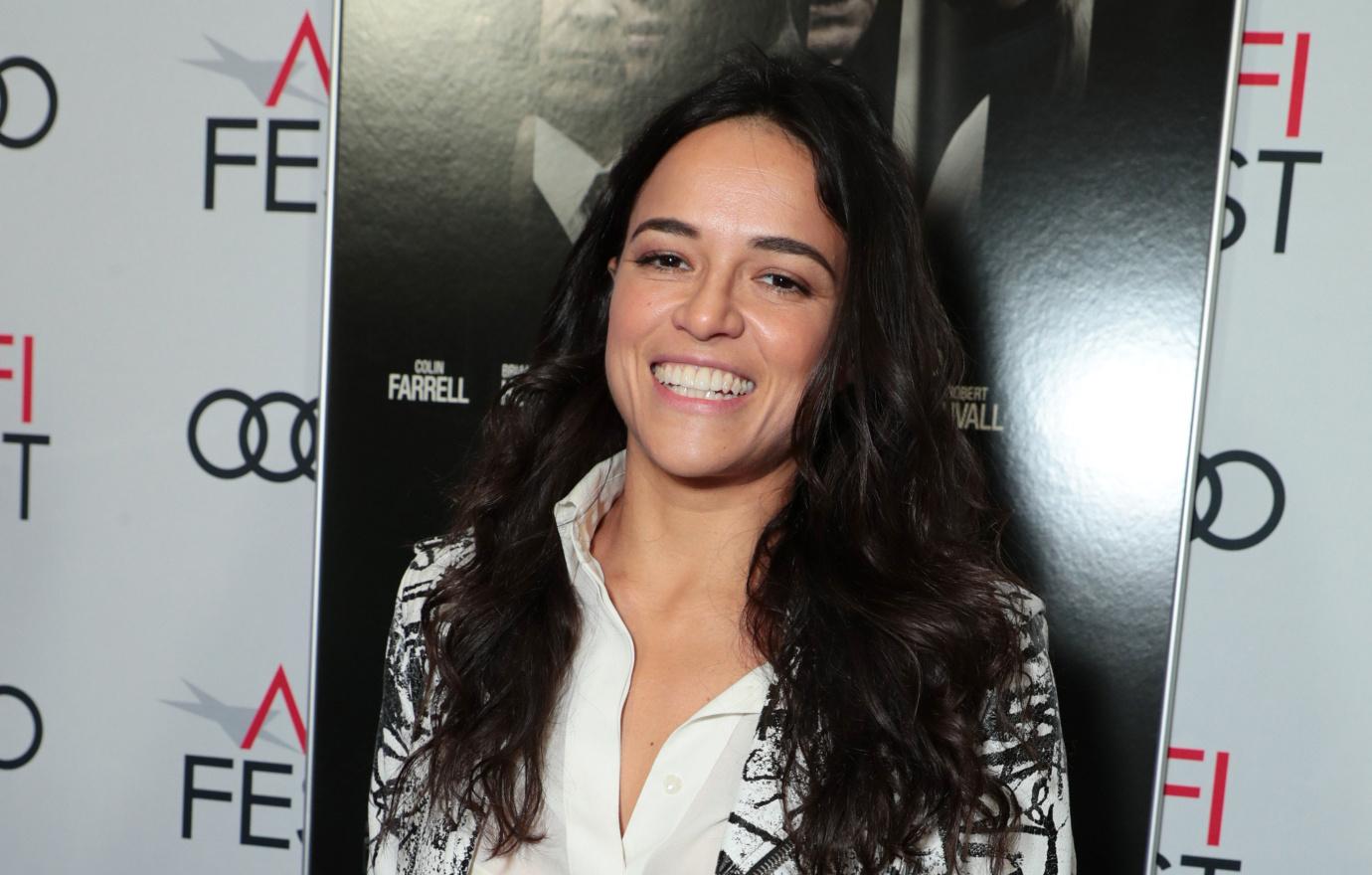 Actress Michelle Rodriguez wears white pants paired with a eye catching white blazer