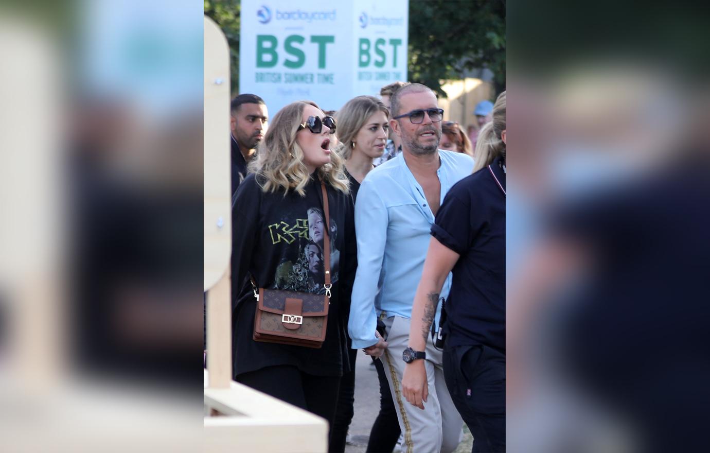 Adele is seen surrounded by bodyguards while holding hands with a male friend in Hyde Park, London, where Celine Dion was headlining.