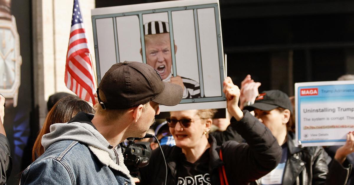 maga supporter trump arraignment protest rips flag