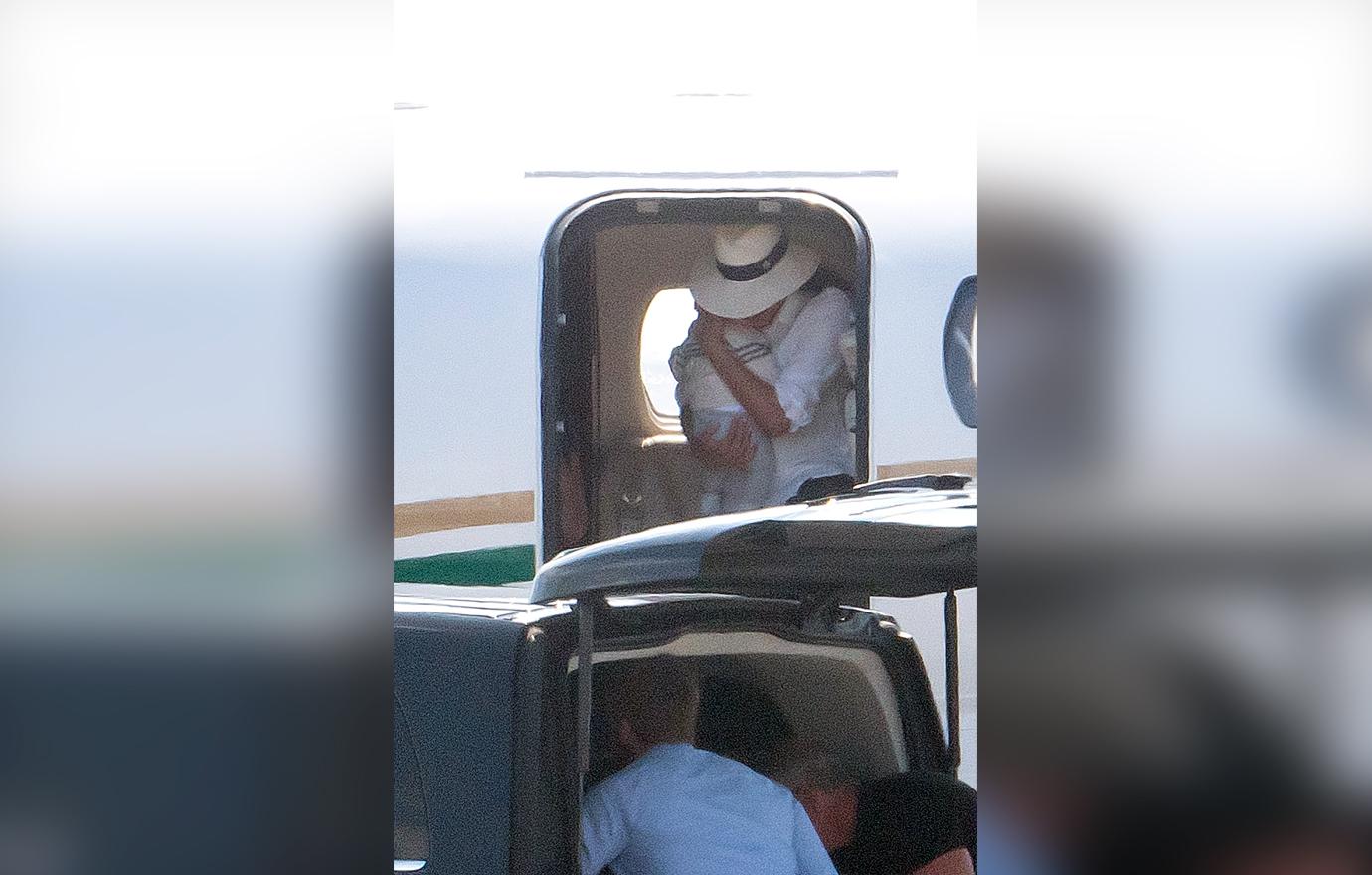 Meghan Markle cradles baby son Archie in both arms as she leaves the luxury private jet