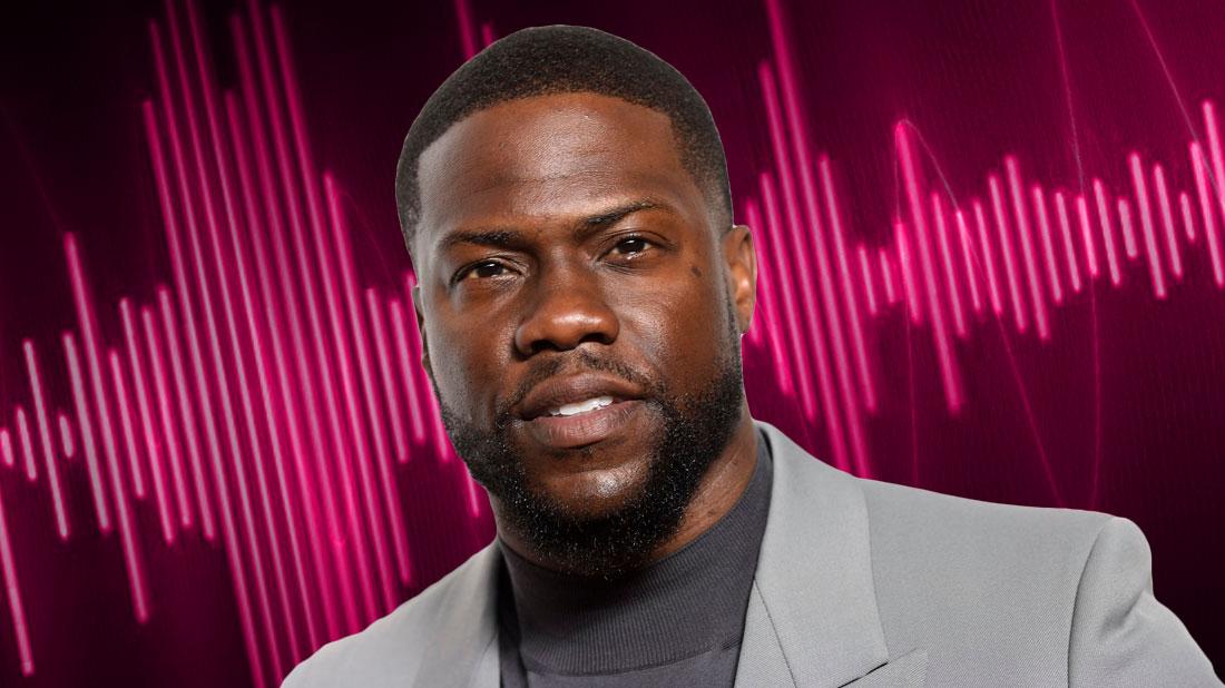 Closeup Of Kevin Hart Wearing Medium Gray Turtleneck and Light Gray Blazer WIth Pink Audio Waves in Background