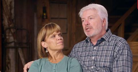 Amy Roloff Sitting Beside Chris Marek Looking Up At Him As They Both Have Serious Expressions