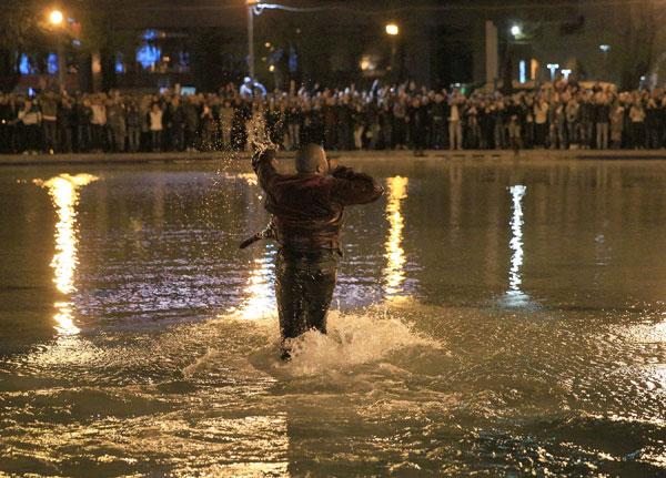 Kanye West jumps into water as fans, cops, jump in along with the soaking wet rapper at last minute concert in Armenia. Kanye decided to organize the show at literally 9pm on late Sunday night and by using social media over 3,000 screaming fans showed up at the duck pond to watch him perform at nearly 1:20am local time. Kanye was on stage singing his hit when his mic started to short out as the crowd noticed. Minutes later he asked a section of the crowd if they could see him and after realizing they could not, he jumped literally into the middle of the duck pond and drops his mic into the water due to it being too wet and ruined. He is then literally surrounded by the fans as they run into the water with him as his bodyguard Pascal is spotted running to his side along with the Armenian National Guard and Police all getting soaking wet to retrieve the rap star. Kanye was then brought closer as a fan tried to touch his hand, the cops pushed him and Kanye reacted to holding the cops back to let the fan get a photo with him in the pond too! Madness occurs in a stampede style follow as Kanye is finally pulled to the top of the pond and is guided with his entourage out of the park with thousands running and following him out of the concert. Kim Kardashian was shown on side stage watching her man perform and was all smiles