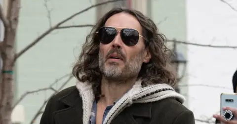 russell brand prosecuted us warner bros execs outtakes victim attacked