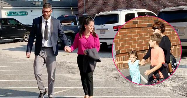 Jenelle Evans wears a magenta shirt while she holds hands with David Eason, who is wearing a suit, heading to court.