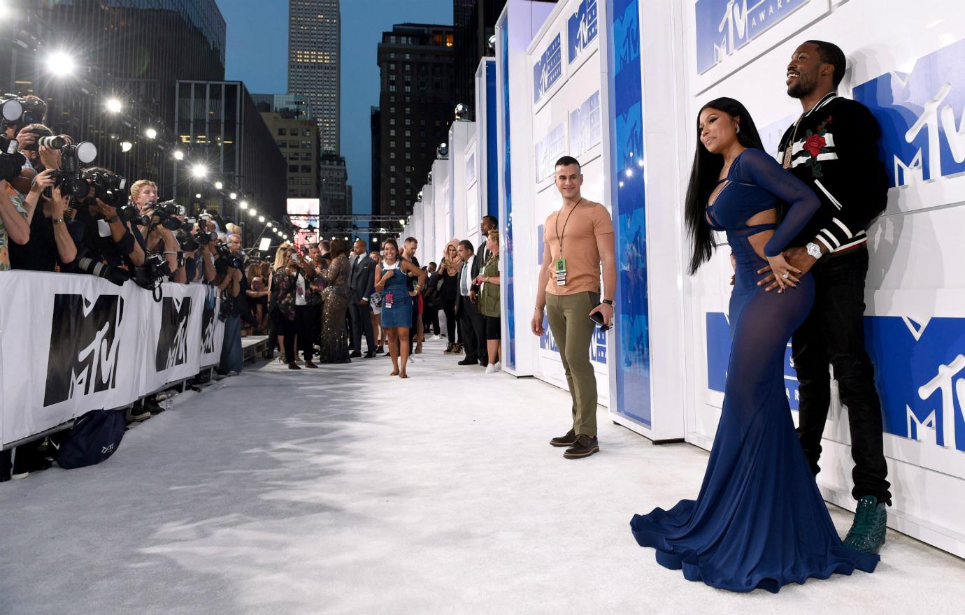 Nicki Minaj leans up against Meek Mill on the red carpet.