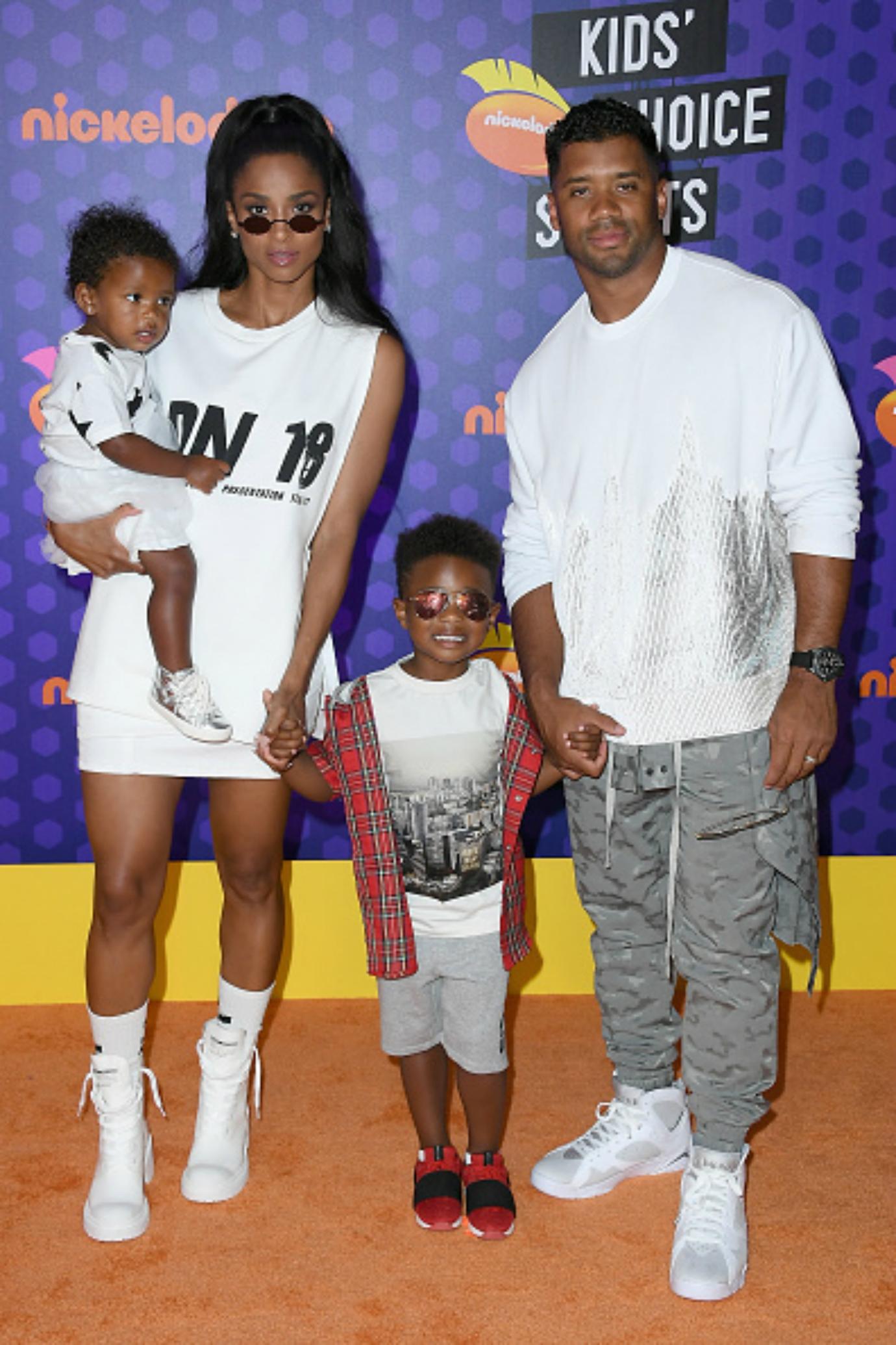 Russel Wilson and Ciara pose on the red carpet with their children.