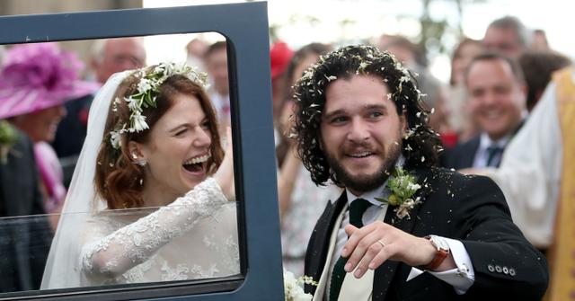 Kit Harington and Rose Leslie smile on their wedding day with their Land Rover Defender getaway car