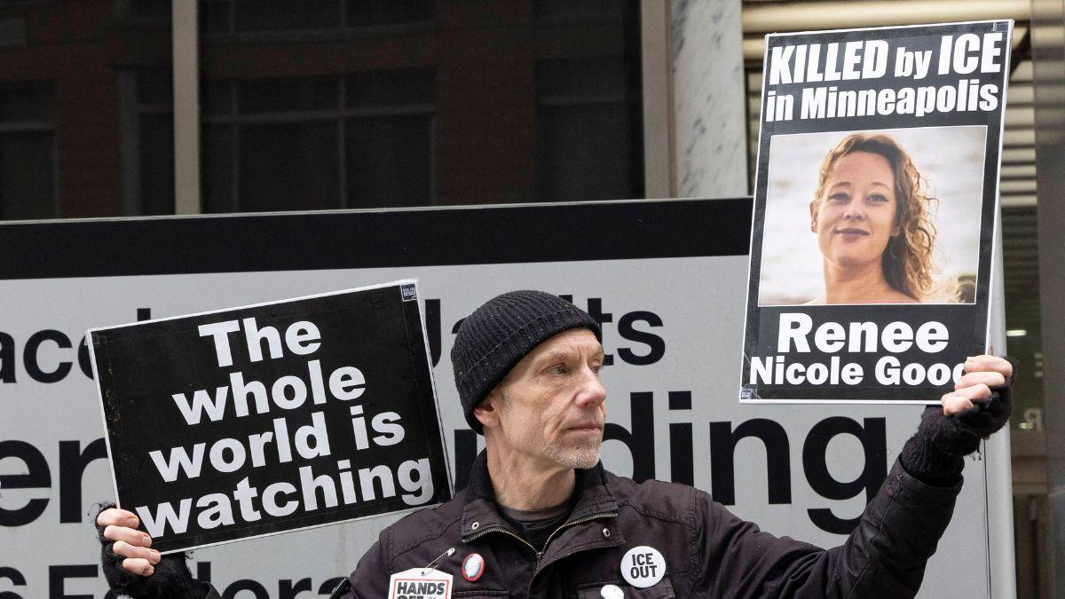 Photo of a man holding a pictgure of Renee Nicole Good
