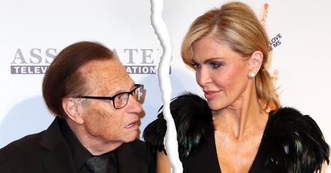 Larry King in Black Suit Holding Hands With Wife Shawn in Black Feather Dress As They Both look At Each Other Concerned With Rip Tear Graphic Through