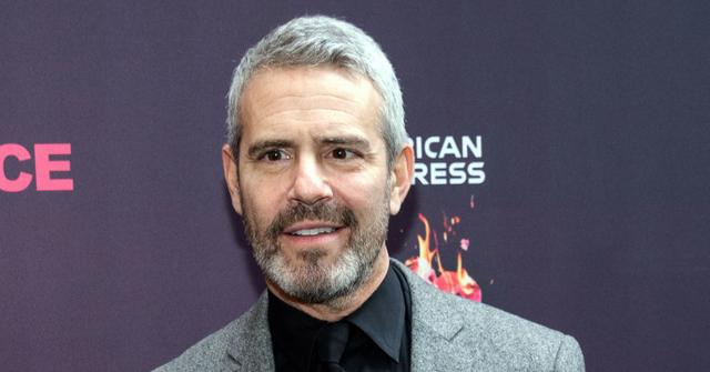 Andy Cohen With Full Beard and Mustache, Wearing Black Shirt and Tie With Gray Heathered Blazer