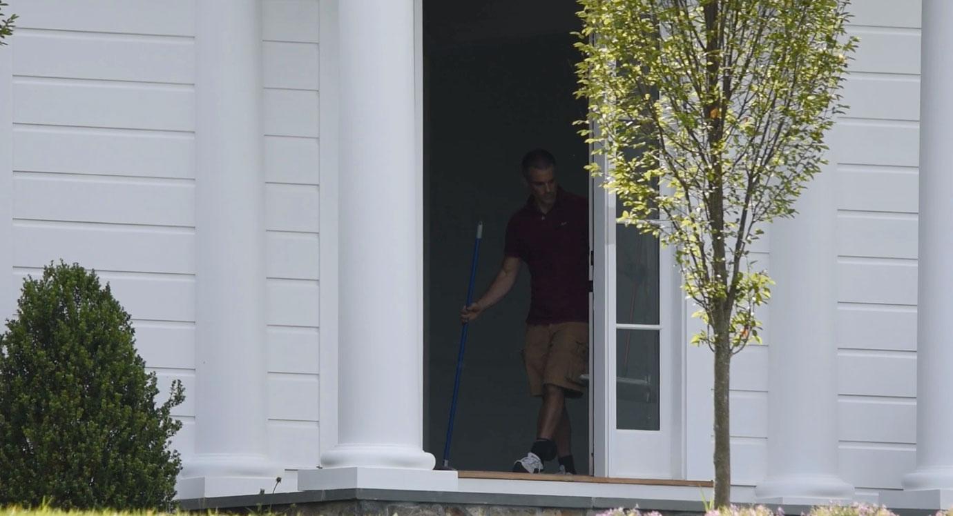 Fotis Dulos standing in front of the house