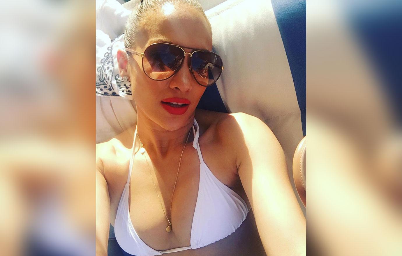 Jennifer Lopez takes a selfie wearing a white bikini.