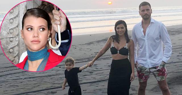 Sofia Richie insetted on the ,left, seen wearing a red jacket and blue scarf. Scott Disick and Kourtney Kardashian are seen on the bach in Bali. Scott Disick is seen wearing a white shirt with floral pants. Kourtney Kardashian is seen wearing a bra and a black skirt.