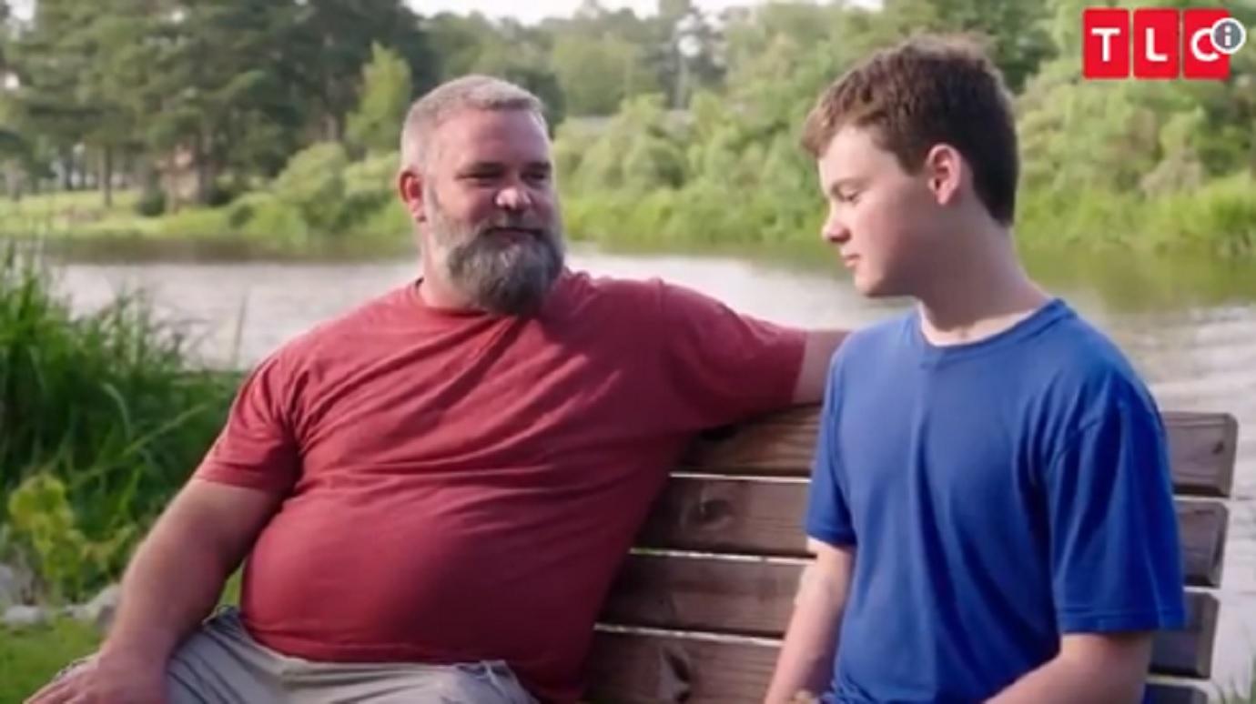 Bernie McGee talks to his son John McGee while sitting on a bench.