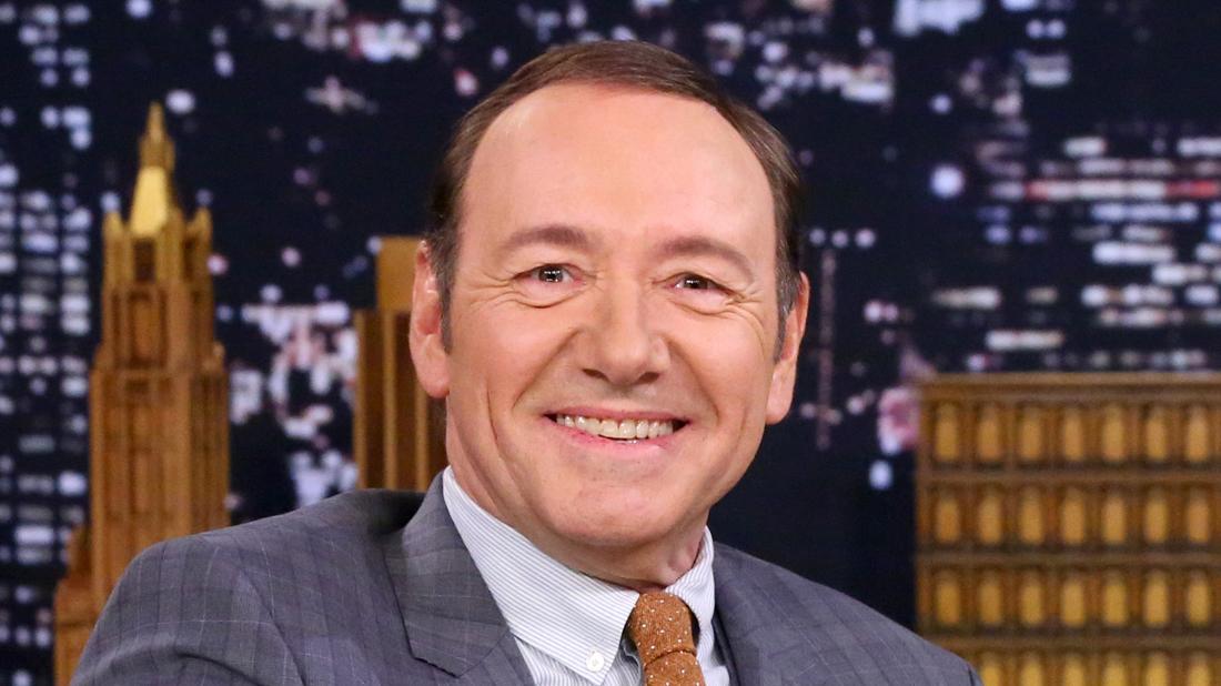 kevin spacey wears a suit and orange tie.