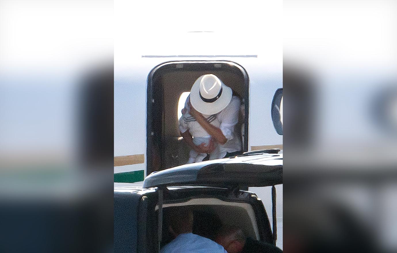 Meghan Markle cradles baby son Archie in both arms as she leaves the luxury private jet